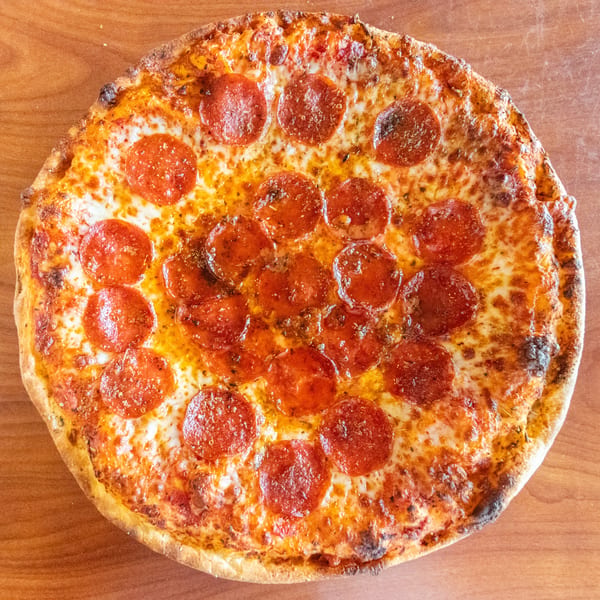 A whole pepperoni pizza from Bella's Pizza Villa, with melted cheese and a golden crust.