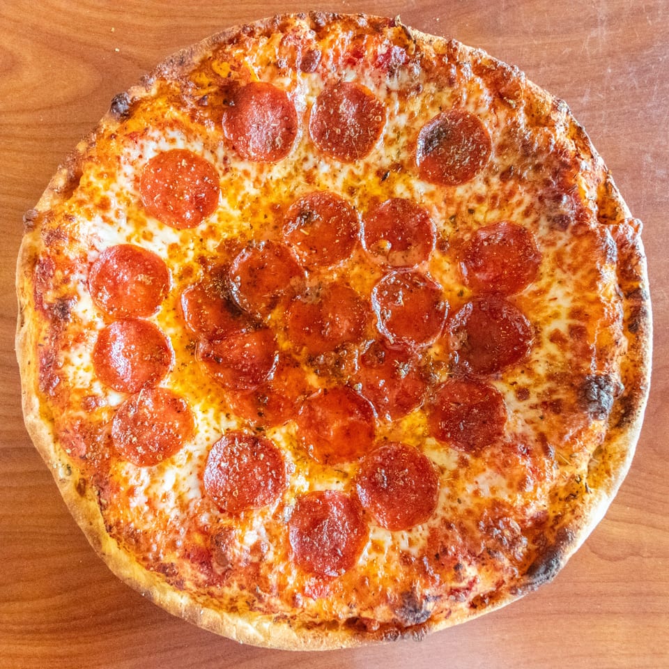 A whole pepperoni pizza from Bella's Pizza Villa, with melted cheese and a golden crust.